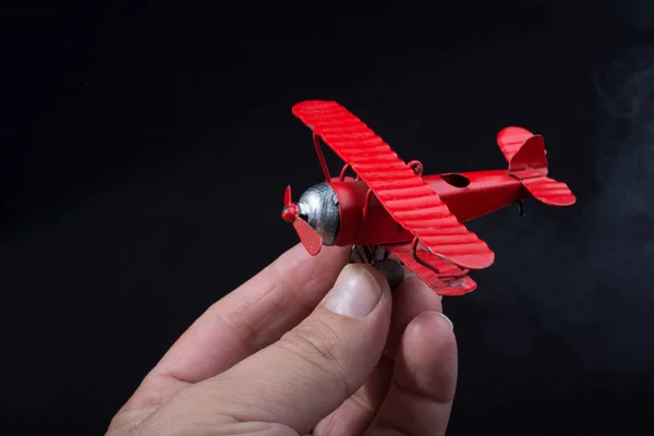 Mão Segurando Avião Brinquedo Vermelho Fundo Preto — Fotografia de Stock