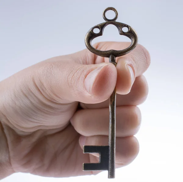 Χέρι Κρατώντας Ένα Ρετρό Στυλ Μεταλλικό Κλειδί Λευκό Φόντο — Φωτογραφία Αρχείου