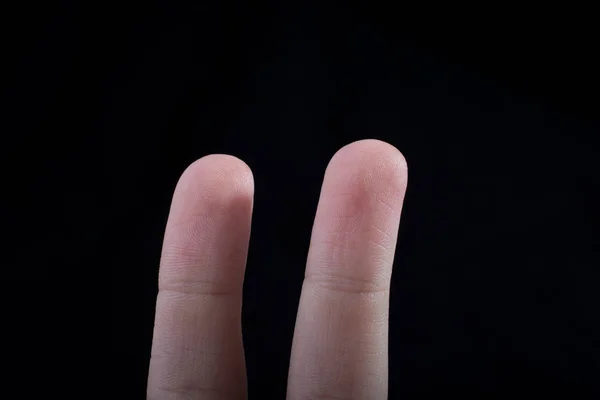 儿童手的两根手指 部分可见于黑色背景 — 图库照片