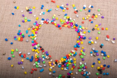 Renkli küçük çakıl tuval zemin üzerinde bir kalp şeklini