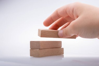 Beyaz arka planda ahşap domino taşları var.