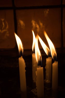 Karanlıkta mum ışığında yanan mumlar.
