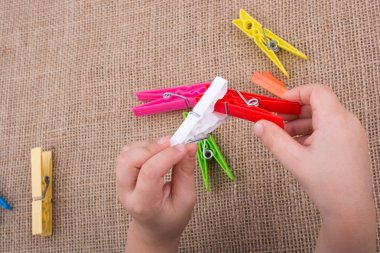 Renk clothespin el keten tuval arka plan üzerinde