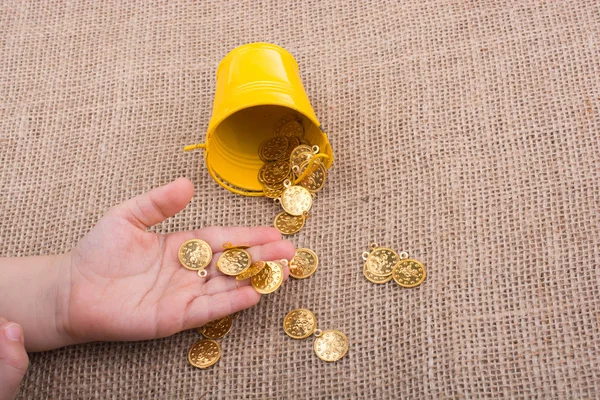 Kova ve sahte altın el üzerinde arka plan bez