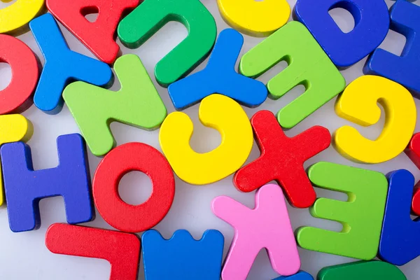 Beyaz arkaplana rastgele dağılmış renkli harf blokları