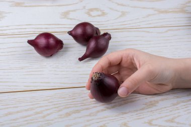 Tüm kırmızı soğan soğanları kahverengi ve ahşap arka planda