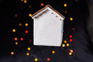 Koyu arkaplanda Bokeh ışıkları olan küçük model ev.
