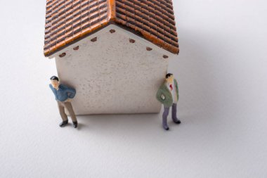 Evin önünde minyatür bir insan figürü.