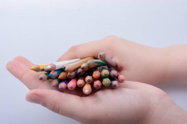 Beyaz arkaplana yerleştirilmiş el ele tutuşan kalemler