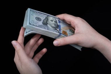 Beyaz arka planda el ele tutuşan Amerikan doları banknotları