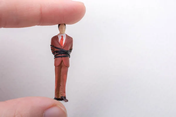 Main Tenant Minuscule Figurine Homme Modèle Attaché Dans Une Corde — Photo