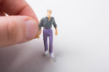 Elindeki minyatür insan figürü.