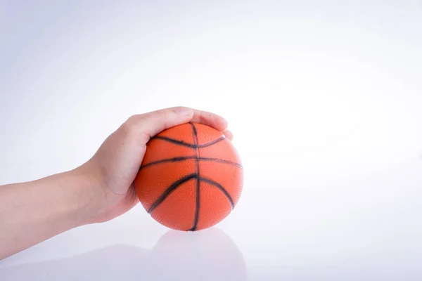 白地にオレンジのバスケット ボールのモデルを持っている手 — ストック写真