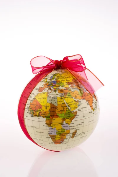 Stock image Globe tied with red ribbon on a white background