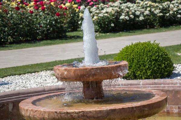 Water gushing off the fountain in rose garden