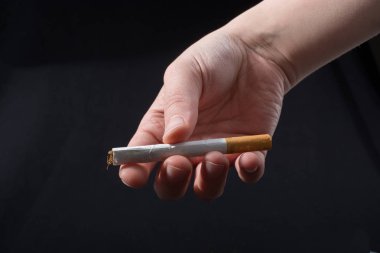 El siyah arka planda sigara dağıtıyor.