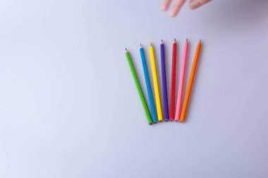beyaz bir arka plan üzerine yerleştirilen renkli kalemler