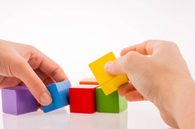 Beyaz arka planda renkli küplerle el oynamak