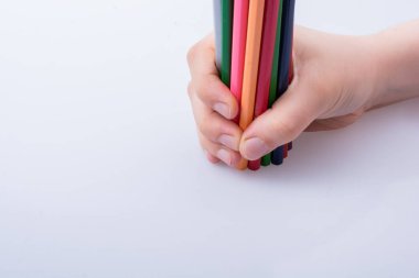 Beyaz arkaplana yerleştirilmiş el ele tutuşan kalemler