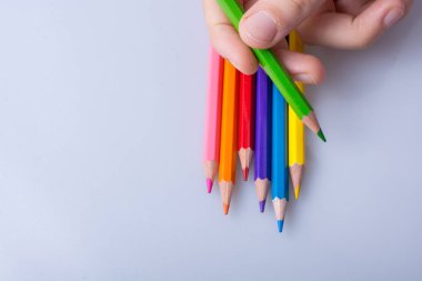 Beyaz arkaplana yerleştirilmiş el ele tutuşan kalemler