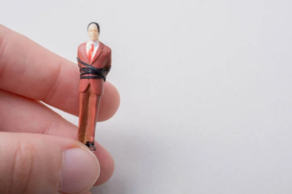 Main Tenant Minuscule Figurine Homme Modèle Attaché Dans Une Corde — Photo