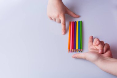 Beyaz arkaplana yerleştirilmiş el ele tutuşan kalemler