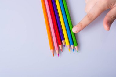 Beyaz arkaplana yerleştirilmiş el ele tutuşan kalemler