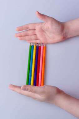 Beyaz arkaplana yerleştirilmiş el ele tutuşan kalemler