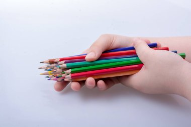 Beyaz arkaplana yerleştirilmiş el ele tutuşan kalemler