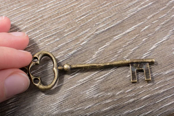 手持复古风格装饰钥匙的木质纹理 — 图库照片