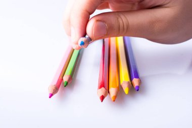 Beyaz arkaplana yerleştirilmiş el ele tutuşan kalemler