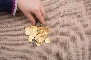 Sahte altınlar üzerinde retro stil bir anahtar tutan el.