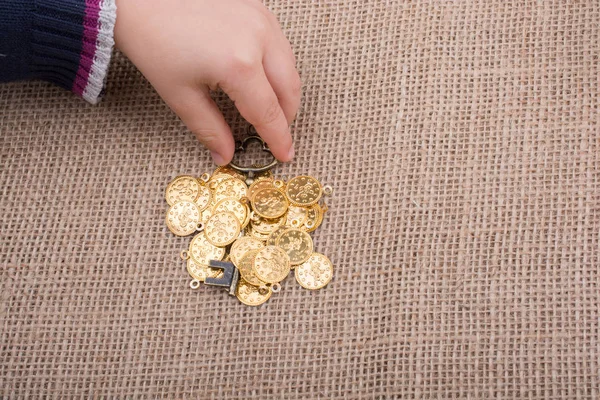 Sahte altınlar üzerinde retro stil bir anahtar tutan el.