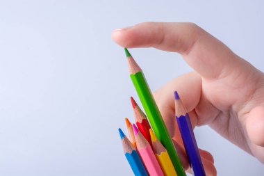 Beyaz arkaplana yerleştirilmiş el ele tutuşan kalemler