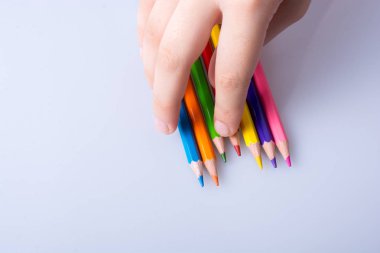 Beyaz arkaplana yerleştirilmiş el ele tutuşan kalemler