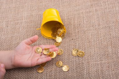 Kova ve sahte altın el üzerinde arka plan bez