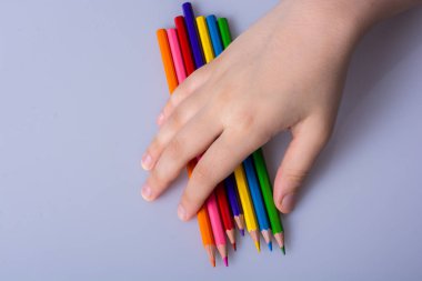 Beyaz arkaplana yerleştirilmiş el ele tutuşan kalemler