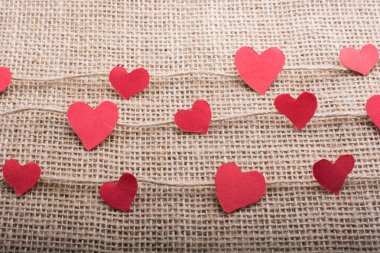 Keten ipliklerle ilgili kalp şeklinde kağıtları olan aşk konsepti