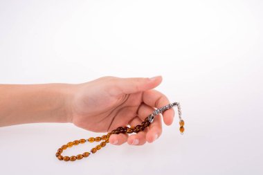 Beyaz bir arka plan üzerinde bir tespih tutan el