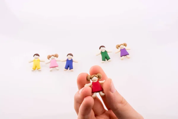 Hand Hält Bunt Gekleidete Kinderfigur Auf Weißem Hintergrund — Stockfoto