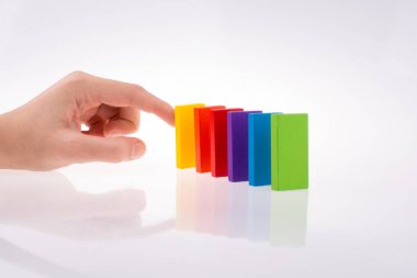 Beyaz arkaplanda renkli domino taşıyla el oyunu