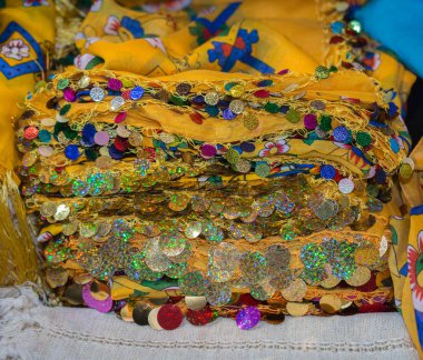 Eşarp kenarlarında bir sürü sahte altın para var.