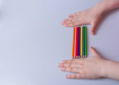 Beyaz arkaplana yerleştirilmiş el ele tutuşan kalemler