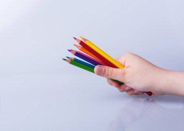 Beyaz arkaplana yerleştirilmiş el ele tutuşan kalemler