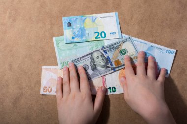 El ele tutuşan Amerikan doları banknotları ahşap arka planda izole edilmiş.