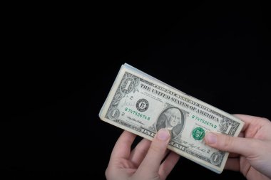 Beyaz arka planda el ele tutuşan Amerikan doları banknotları