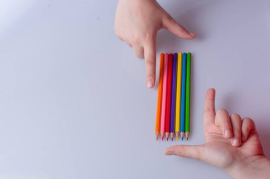 Beyaz arkaplana yerleştirilmiş el ele tutuşan kalemler