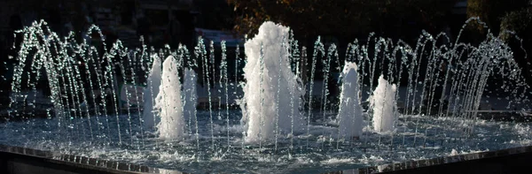 公園内のプールで輝く水を噴出する噴水 — ストック写真