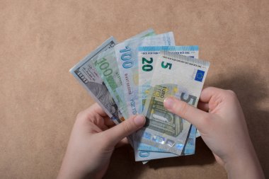 El ele tutuşan Amerikan doları banknotları ahşap arka planda izole edilmiş.