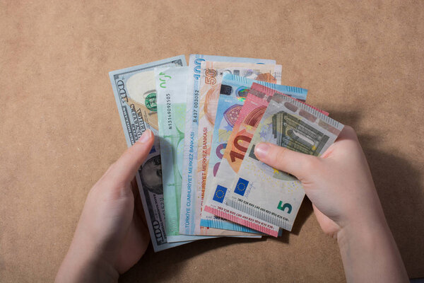 Hand holding American dollar  banknotes isolated on wooden background